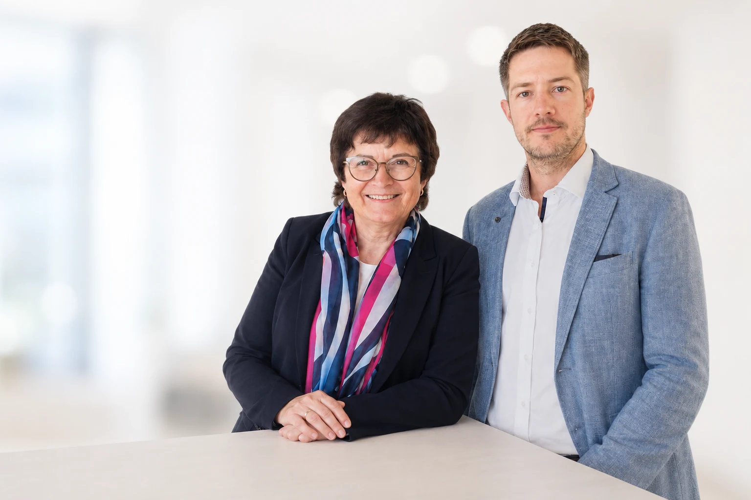Mag. Brigitte Edinger und Markus Edinger, MSc (WU), vor hellem Hintergrund